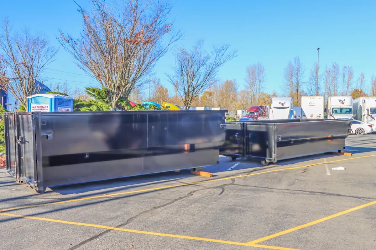 Professional dumpster rental service with roll-off container on residential driveway in Lower Windsor
